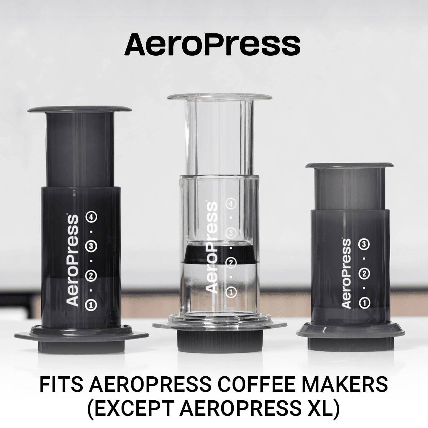Three AeroPress coffee makers of various sizes are shown side by side on a white surface with text below: "Fits AeroPress Coffee Makers (Except AeroPress XL)," highlighting that the AeroPress Paper Micro-Filters are compatible replacement filters.