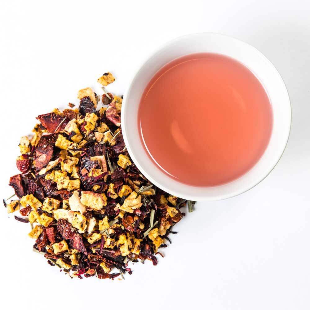 a pile of loose leaf next to a cup of brewed tea - Strawberry Shindig